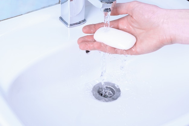 Handen wassen in de gootsteen wrijven met zeepman voor coronavirus, preventie van covid-19, hygiëne om de verspreiding van het coronavirus te stoppen. vernietiging van het virus