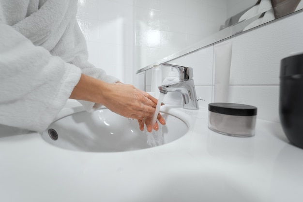 Handen wassen in witte badkamer