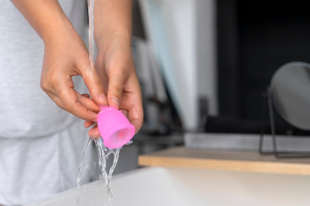 Foto handen wassen menstruatiecup vooraanzicht