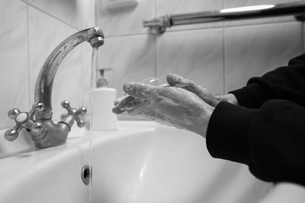 Handen wassen met water en zeep om coronavirus te voorkomen Handen wassen zwart-wit foto