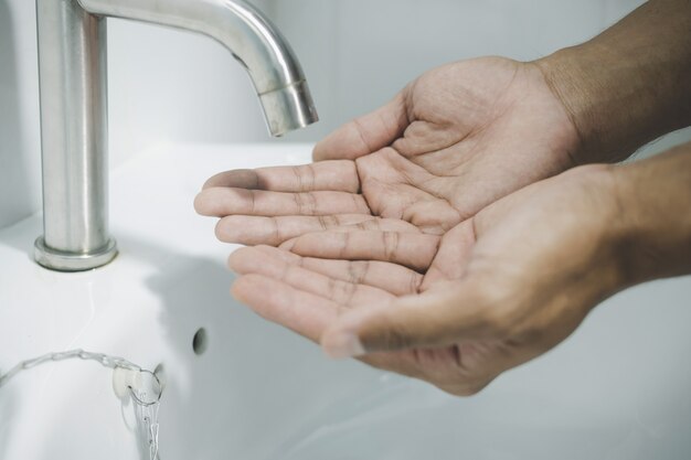 Handen wassen met water in de gootsteen