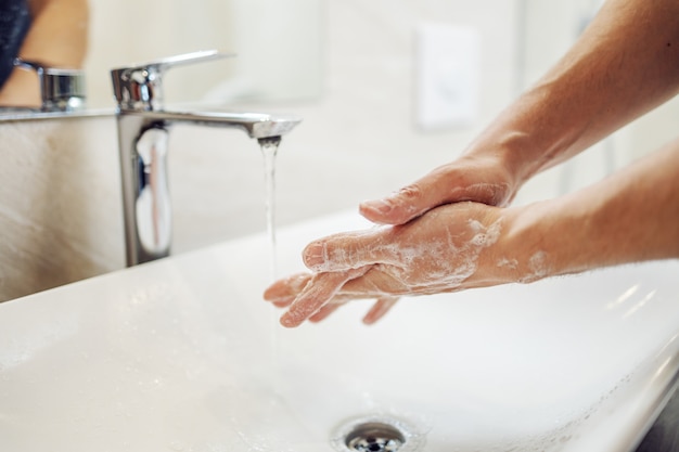 Handen wassen met zeep man voor preventie van coronavirus, hygiëne om verspreiding van coronavirus te stoppen.