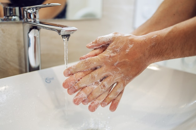 Foto handen wassen met zeep man voor preventie van coronavirus, hygiëne om verspreiding van coronavirus te stoppen.