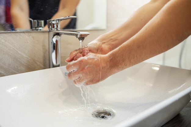 Handen wassen met zeep man voor preventie van coronavirus, hygiëne om verspreiding van coronavirus te stoppen.