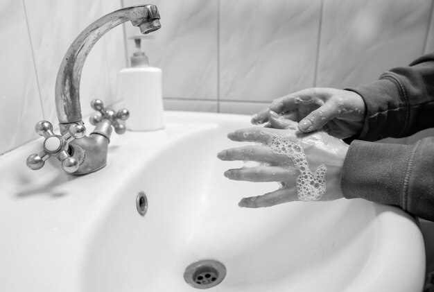 Handen wassen wrijven met zeep man voor coronavirus preventie zwart-wit foto