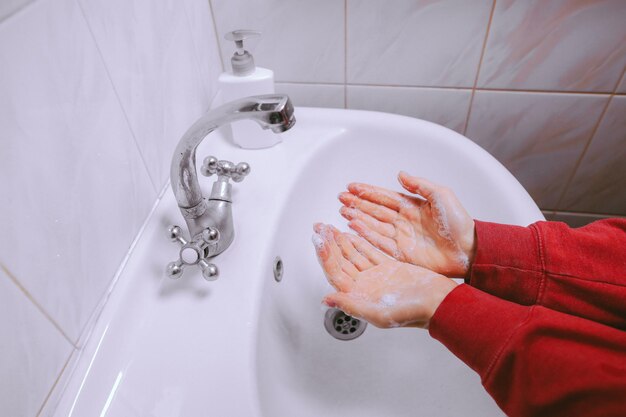 Handen wassen wrijven met zeep man voor coronaviruspreventie vintage fotoverwerking