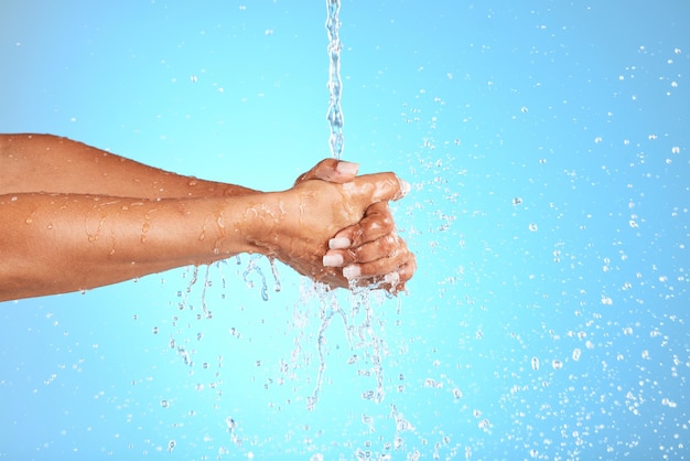 Handen water en wassen voor schone hygiëne, gezondheid of welzijn tegen een blauwe studioachtergrond