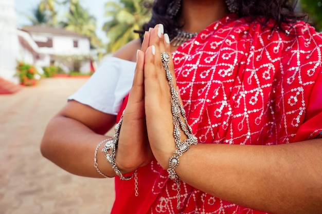 Handen zilveren armband ring sieraden gebaar namaste close-up Indiase vrouw in traditionele sari rode jurk bidden in hindoe tempel goa india Hinduism.girl katholicisme Delhi om yoga meditatie vrouwelijk model