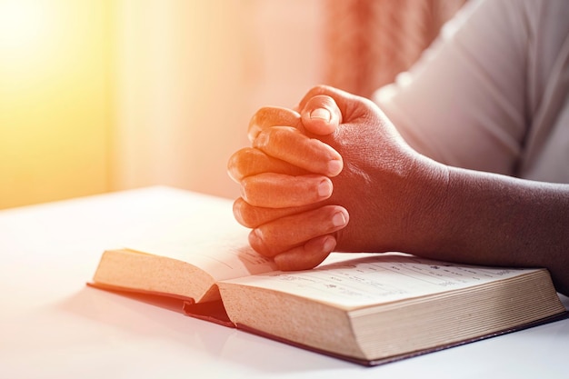 Handenvrouw die met bijbel Christelijk concept bidden