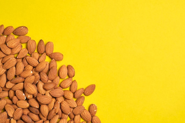 Photo handful of almonds yellow background