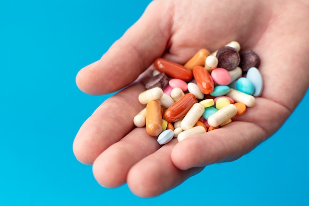 A handful of colored pills on the palm. 