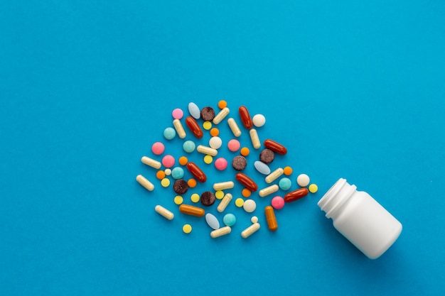 A handful of colored pills spilled out of the can. Medical concept