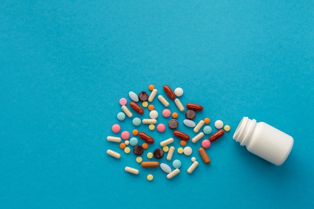 Handful of colored pills spilled out of the can