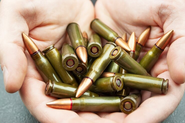 Handful of green 7.62 mm cartridges for Kalashnikov assault rifle in man's hands.