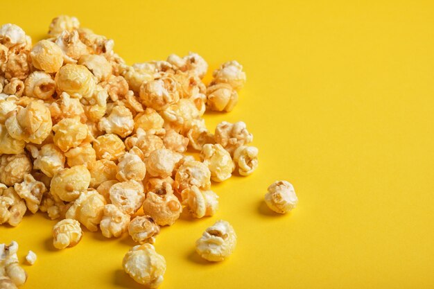 A handful of popcorn on a yellow background