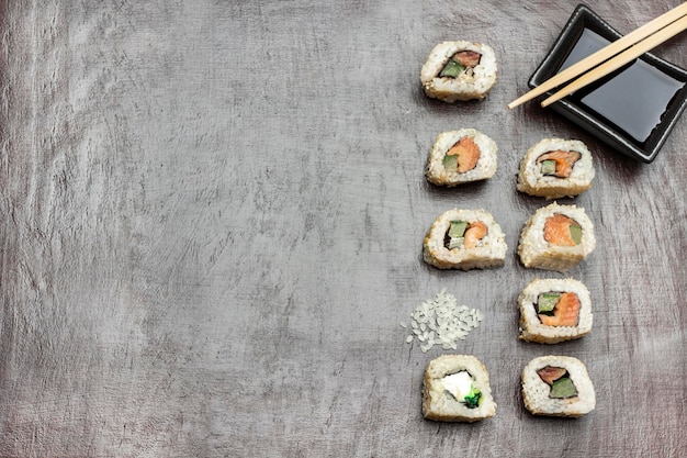 Handful of rice and sushi rolls Chopsticks and soy sauce in black bowl