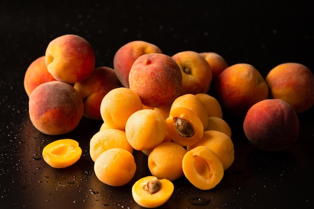 A handful of ripe raw apricots on a dark background