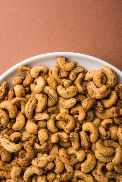 Photo a handful roasted spiced cashew nuts  or masala kaju served in a bowl, selective focus