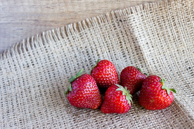 A handful of strawberries on sackcloth, fresh strawberries from the garden