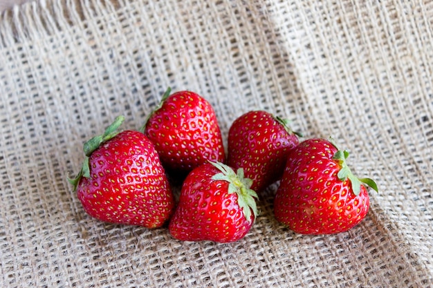 A handful of strawberries on sackcloth, fresh strawberries from the garden