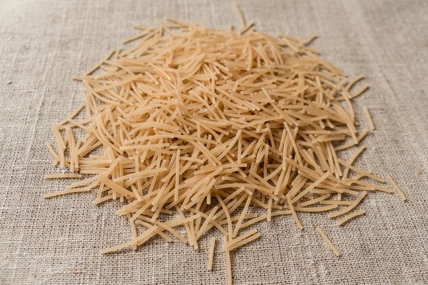 A handful of vermicelli on a canvas background