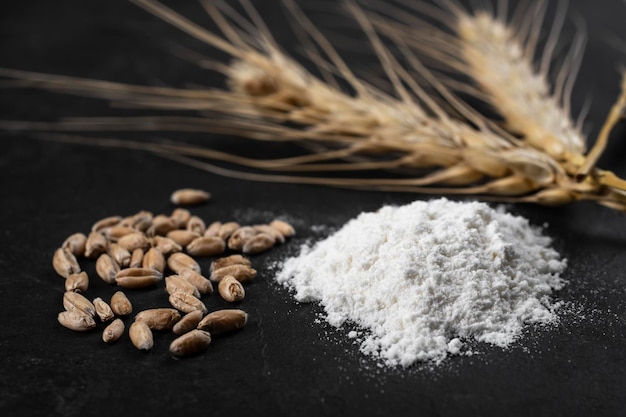 A handful of wheat flour and wheat grains close-up.