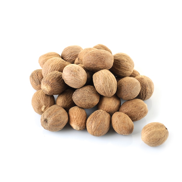 A handful of whole nutmegs on a white background