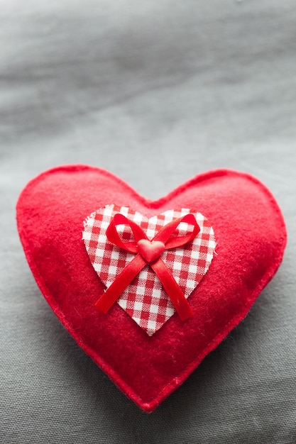 Handgemaakt pluche rood hart op het zachte kussen Romantische liefde