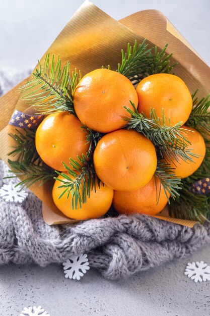 Handgemaakt winterfruitboeket van mandarijn en kerstboomtakken