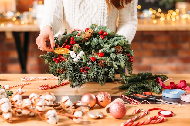 Handgemaakt winterinterieur. dame met groene dennenboom krans.