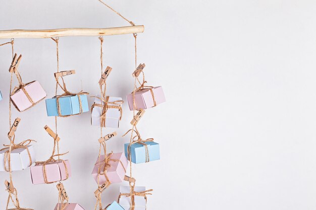 Handgemaakte adventskalender met geschenkdozen die aan touwen hangen