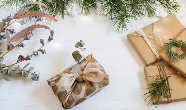 Foto handgemaakte alternatieve geschenkdozen voor kerstmis verpakt in hergebruikdoek en ambachtelijk papier in japanse furoshiki-stijl