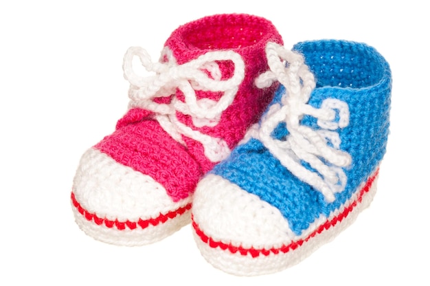 Handgemaakte blauwe en roze baby laarzen geïsoleerd op witte achtergrond