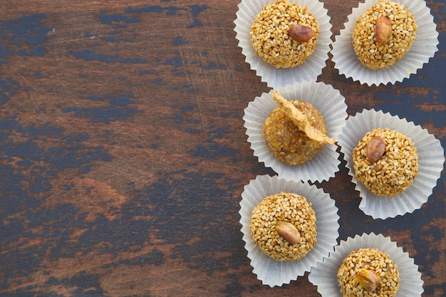 Handgemaakte dieettruffels met gedroogde vruchten en noten op een oud zwart houten oppervlak. Vrije ruimte voor een tekst. Bovenaanzicht