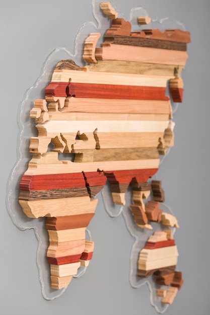 Handgemaakte houten kaart van verschillende houtsoorten in vorm of continenten op lichtgrijze achtergrond