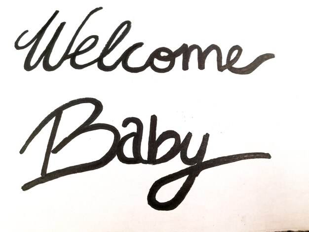 Foto handgemaakte illustratie geschreven op een witte achtergrond die het welkom van een baby aangeeft