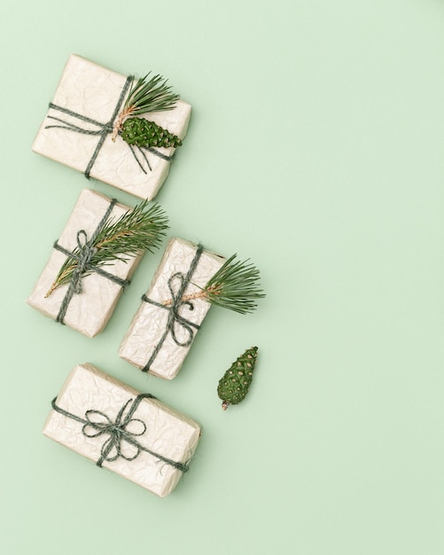 Handgemaakte kerstcadeaudoos of cadeautjes versierd met natuurlijke dennentakken en groene dennenappels