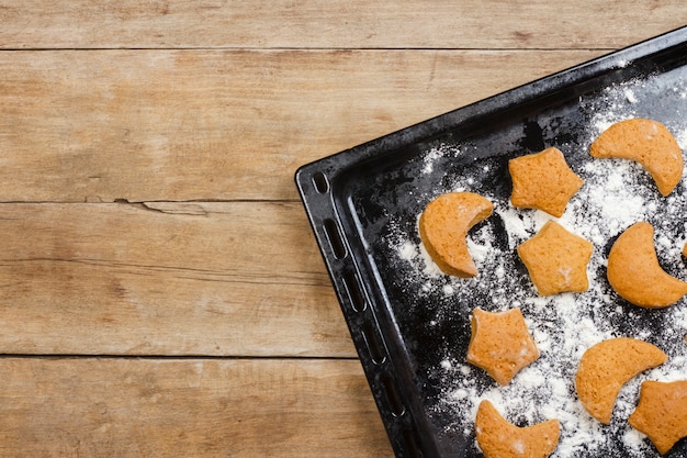 Handgemaakte koekjes op een bakplaat op een houten oppervlak. Plat lag, bovenaanzicht.