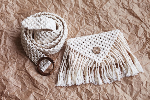 Handgemaakte macrame heuptas op ambachtelijke papier achtergrond ECO vriendelijke natuurlijke macrame katoenen heuptas Hobby breien handgemaakte macrame Modern zomer concept