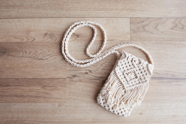 Handgemaakte macrame tas op houten achtergrond eco vriendelijke natuurlijke macrame katoenen tas voor vrouw hobby breien handgemaakte macrame modern zomer concept