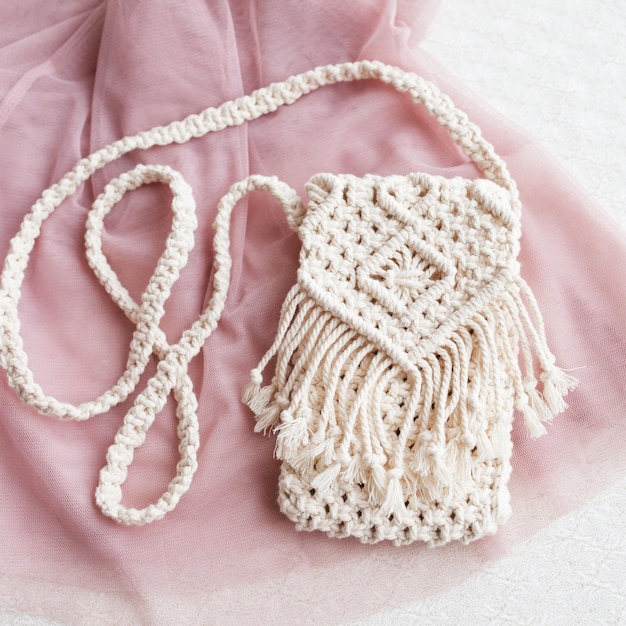 Handgemaakte macrame tas op roze achtergrond ECO vriendelijke natuurlijke macrame katoenen tas voor vrouw Hobby breien handgemaakte macrame Modern zomer concept