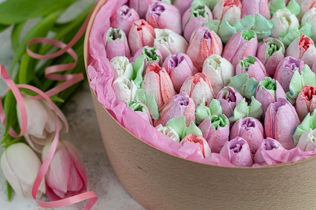 Handgemaakte marshmallows in houten verpakkingen op een lichte achtergrond met bloemen. Het concept van de feestdagen Vrouwendag en Valentijnsdag. ruimte kopiëren.