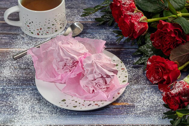Handgemaakte marshmallows op een lichte achtergrond in de vorm van rozen, hortensia's en tulpen. Er zijn bloemen in de buurt. Vrouwendag, Valentijnsdag. ruimte kopiëren.