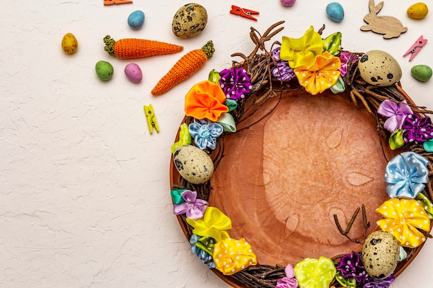 Handgemaakte rieten krans van Pasen met kwarteleitjes en handgemaakte bloemen