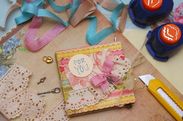 Handgemaakte scrapbooking postkaart en gereedschap liggend op een tafel