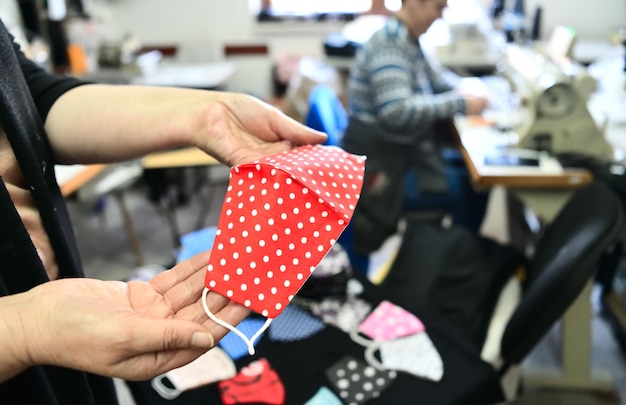 Foto handgemaakte trendy beschermende coronavirus-gezichtsmaskerproductie, gezondheidszorgstof en textielindustrie in nieuwe normale covid19 pandemische lockdown