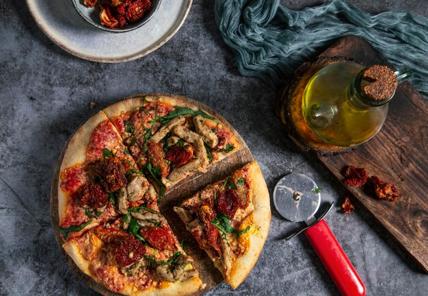 Handgemaakte vegan pizza met tofu zongedroogde tomaten en gesneden rucola