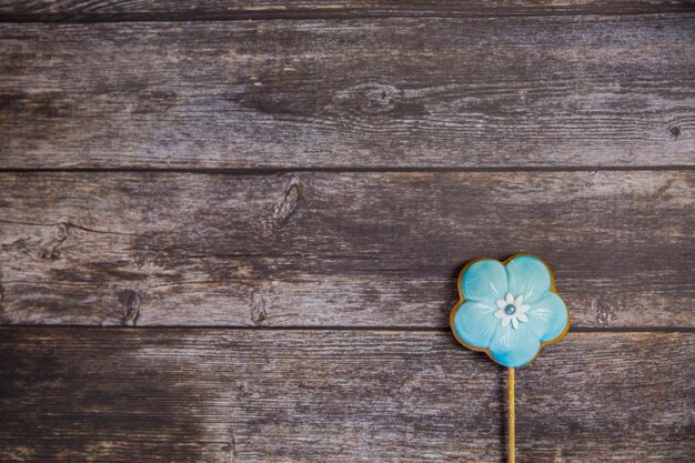 Handgeschilderde peperkoek blauwe bloem op houten achtergrond Bovenaanzicht Zoet dessert als cadeau voor Vrouwendag op 8 maart