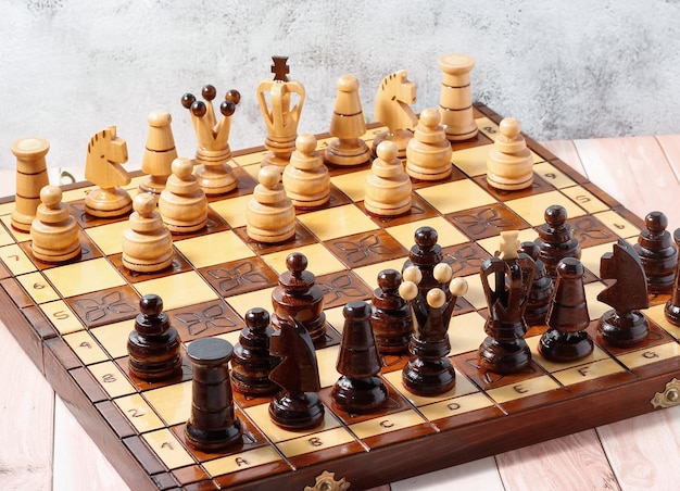 Handgesneden schaakstukken op een handgemaakt houten schaakbord. Bedrijfsstrategie, tactiekconcept