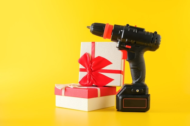 Handheld cordless power drill, hand battery screwdriver and gift boxes. Concept of gift surprise for men, copy space